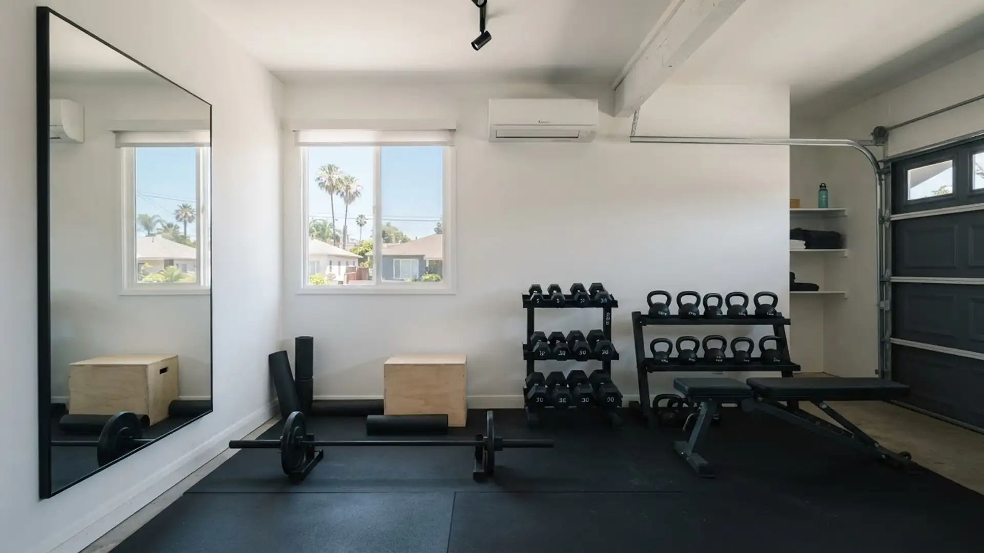 Converted garage home gym with rubber flooring, mirror wall, and mini-split air conditioning
